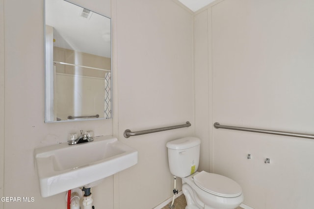 bathroom featuring sink, toilet, and a shower with curtain