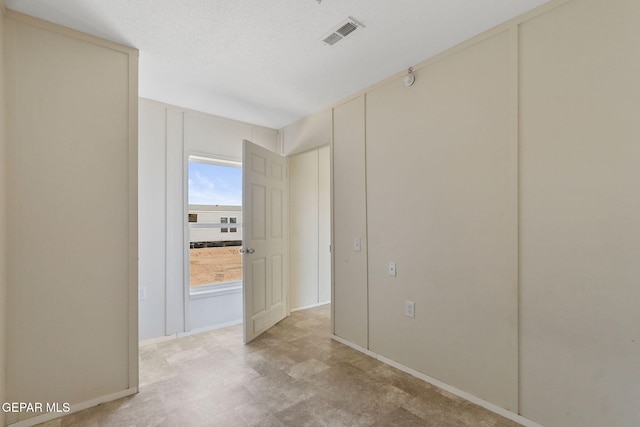 unfurnished room featuring a textured ceiling