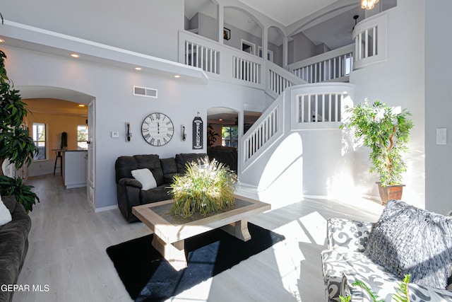 living room with a high ceiling and light hardwood / wood-style flooring