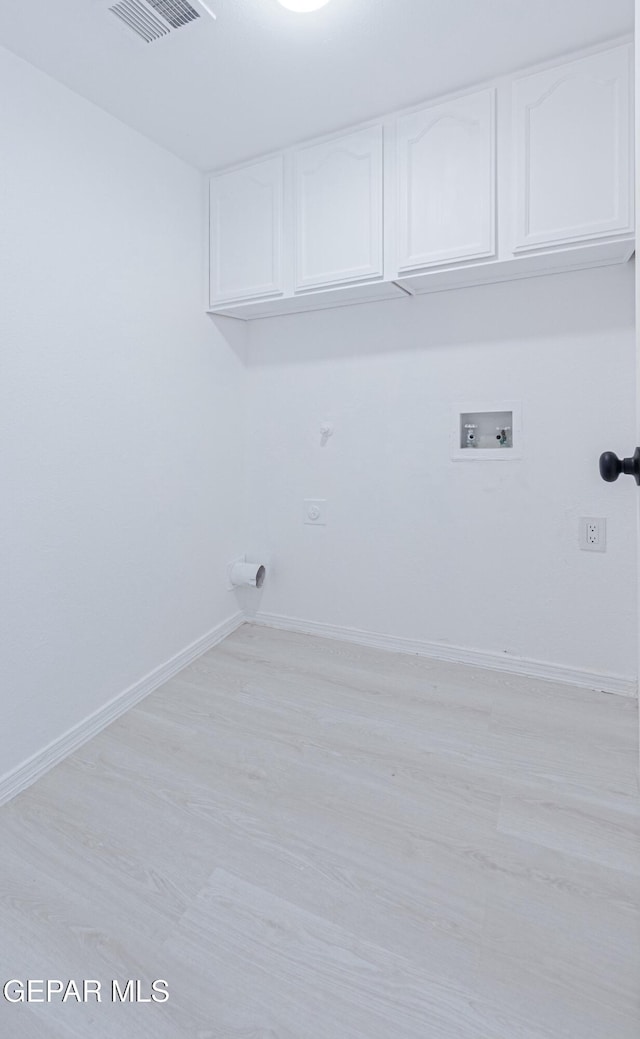 washroom featuring cabinets, light hardwood / wood-style floors, hookup for a washing machine, and electric dryer hookup