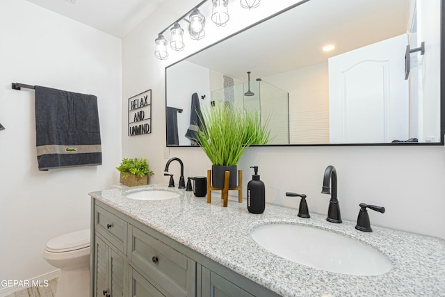 bathroom featuring a shower with door, toilet, and vanity