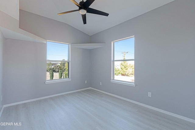 empty room with ceiling fan, lofted ceiling, and light hardwood / wood-style floors