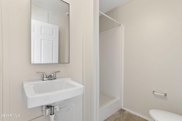 bathroom featuring walk in shower, sink, and toilet