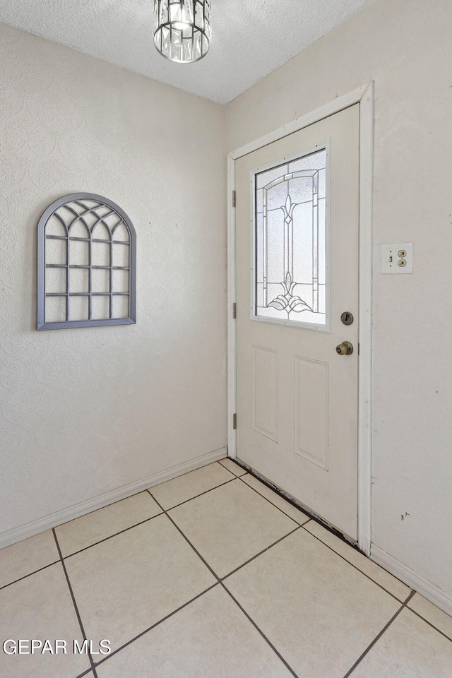 entrance foyer with a textured ceiling and light tile patterned flooring