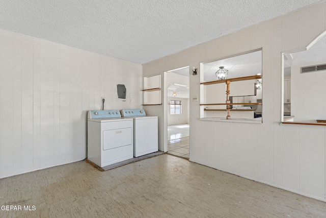 laundry room featuring wooden walls and separate washer and dryer