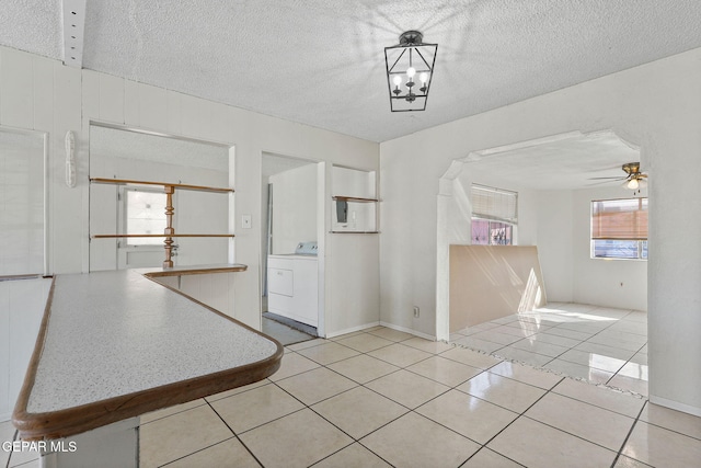 interior space featuring ceiling fan, washer / clothes dryer, and a textured ceiling