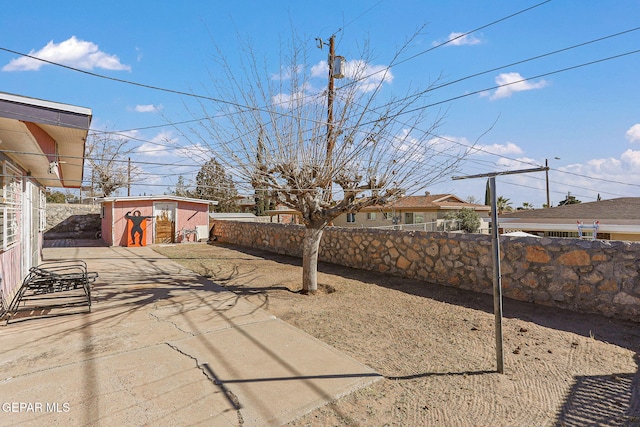 view of yard featuring a storage shed and a patio area