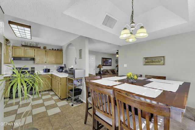 dining room featuring ceiling fan with notable chandelier, a textured ceiling, and light tile patterned flooring