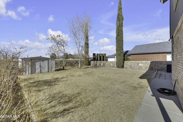 view of yard featuring a storage shed and a patio