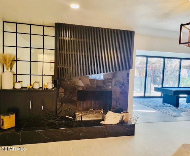 living room featuring pool table and a tiled fireplace