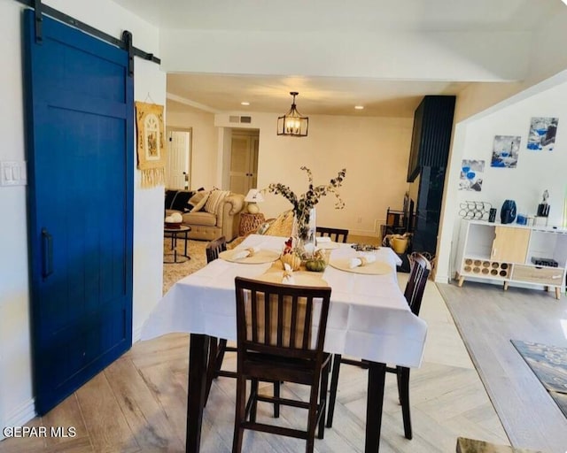 dining area featuring a barn door and light wood-type flooring