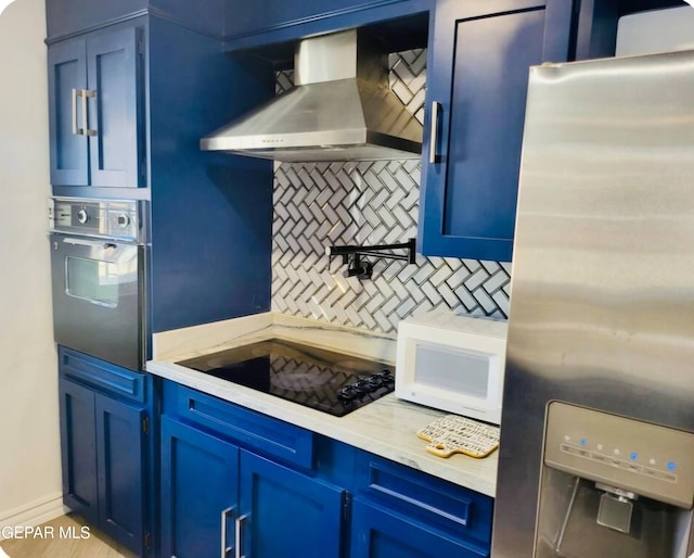 kitchen featuring tasteful backsplash, black electric stovetop, stainless steel refrigerator with ice dispenser, wall oven, and wall chimney exhaust hood