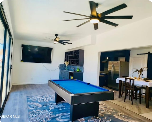 recreation room featuring ceiling fan, pool table, hardwood / wood-style floors, and a barn door