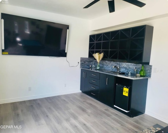 bar with ceiling fan and light hardwood / wood-style floors