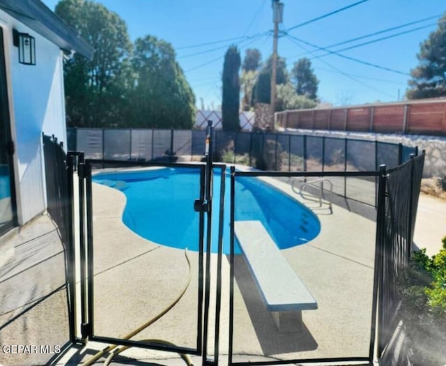 view of pool featuring a diving board