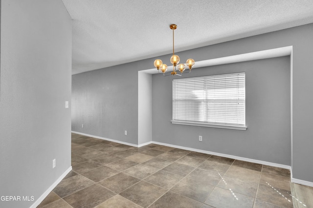 unfurnished room with a chandelier and a textured ceiling