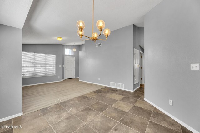 spare room with lofted ceiling and a chandelier