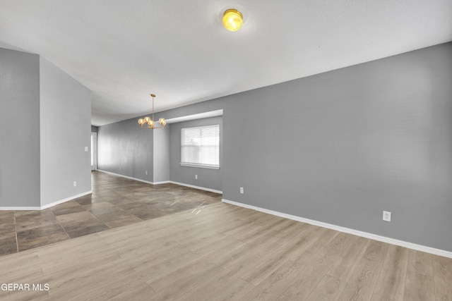 unfurnished room featuring light hardwood / wood-style flooring and a notable chandelier