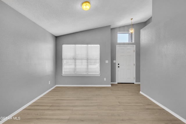 foyer featuring a textured ceiling and lofted ceiling