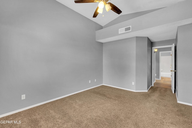 empty room featuring vaulted ceiling, ceiling fan, and carpet flooring