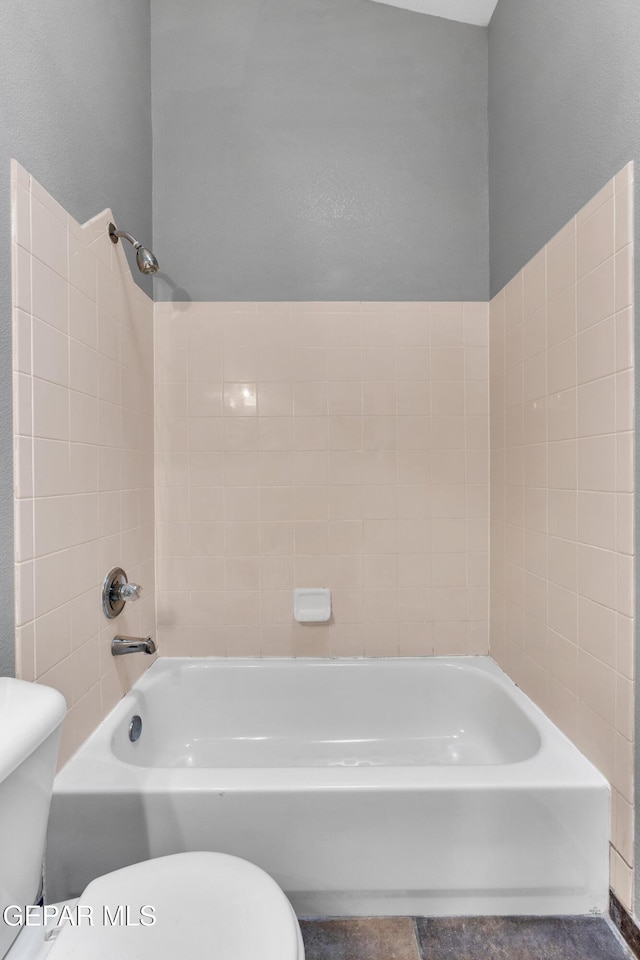 bathroom featuring toilet and  shower combination