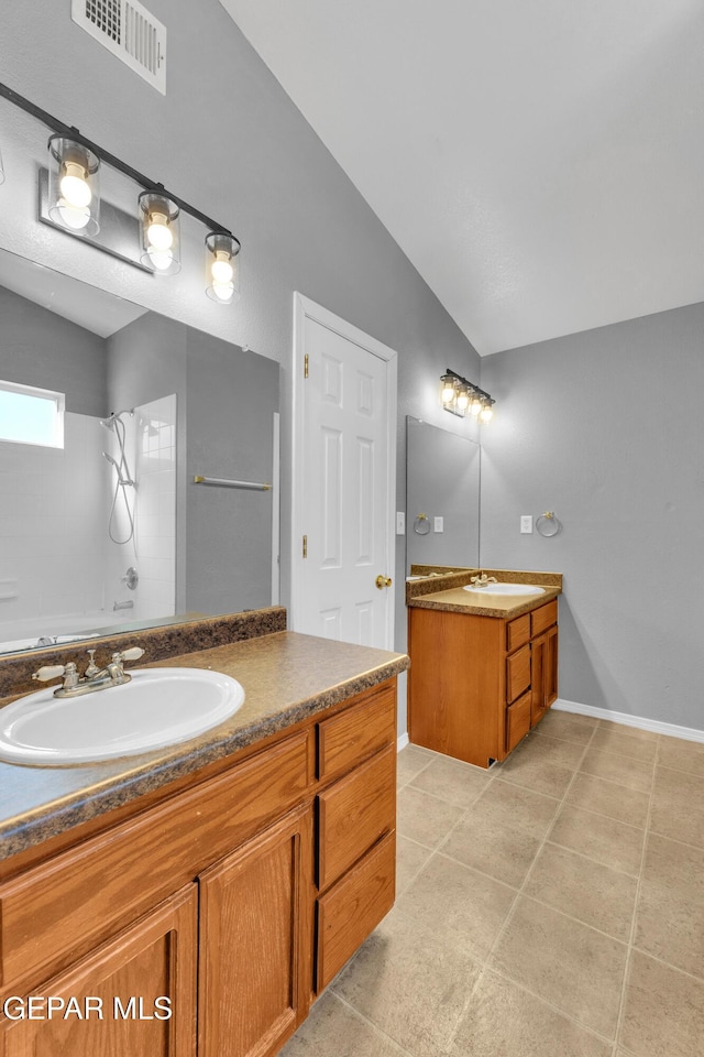 bathroom with vaulted ceiling, tile patterned floors, vanity, and shower / bathing tub combination