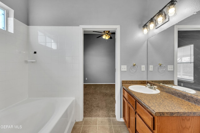 bathroom with a tub to relax in, vanity, ceiling fan, and tile patterned floors