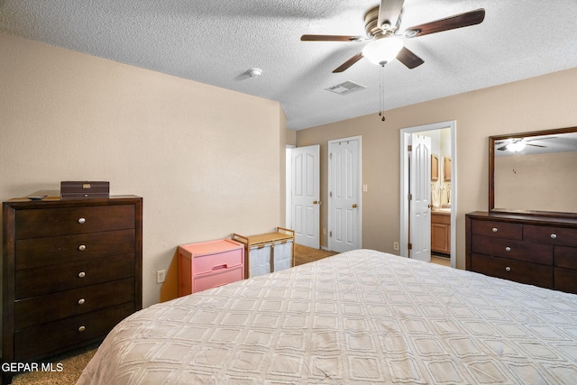 bedroom with ceiling fan, a textured ceiling, and ensuite bathroom