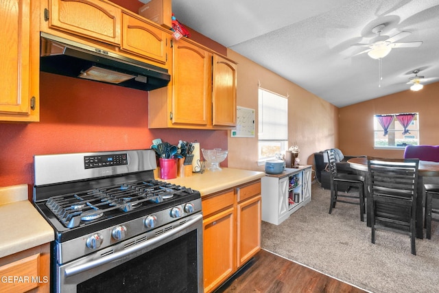 kitchen with lofted ceiling, ceiling fan, stainless steel range with gas stovetop, a textured ceiling, and dark hardwood / wood-style flooring