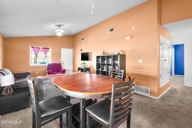 carpeted dining room with vaulted ceiling and ceiling fan