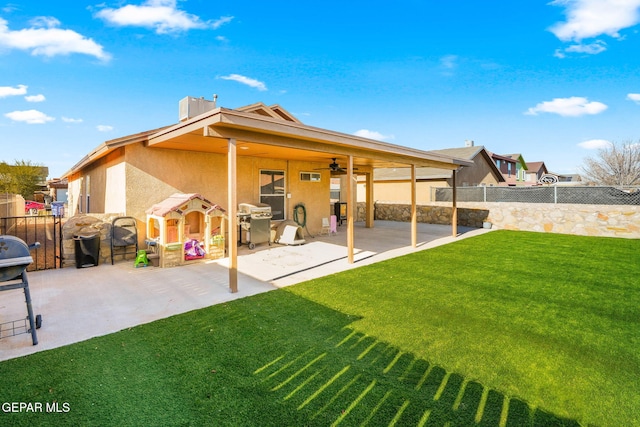 back of property featuring ceiling fan, a yard, and a patio