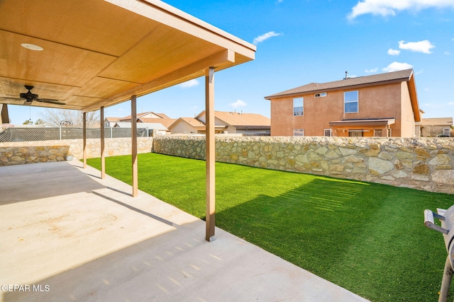 view of yard with ceiling fan and a patio