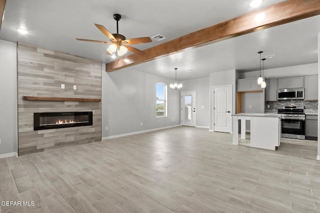 unfurnished living room with a fireplace, beamed ceiling, ceiling fan with notable chandelier, and light hardwood / wood-style flooring