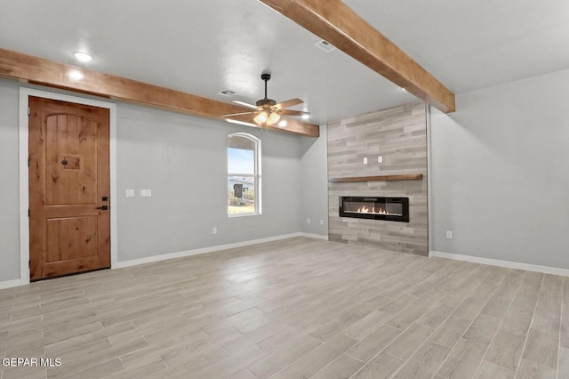 unfurnished living room with ceiling fan, light hardwood / wood-style floors, beam ceiling, and a tiled fireplace