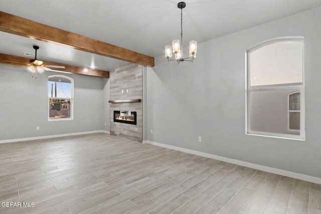 unfurnished living room with a tiled fireplace, beamed ceiling, and ceiling fan with notable chandelier