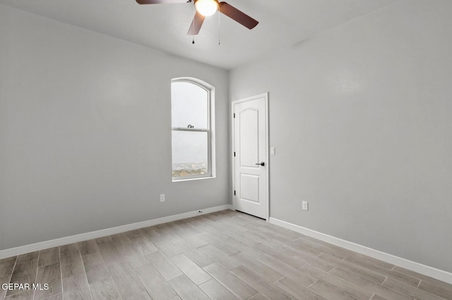 empty room with ceiling fan and light hardwood / wood-style floors