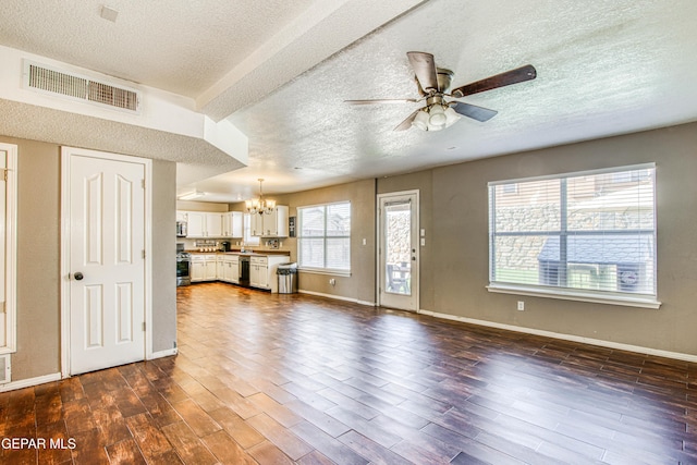 unfurnished living room featuring ceiling fan with notable chandelier, a textured ceiling, and dark hardwood / wood-style flooring