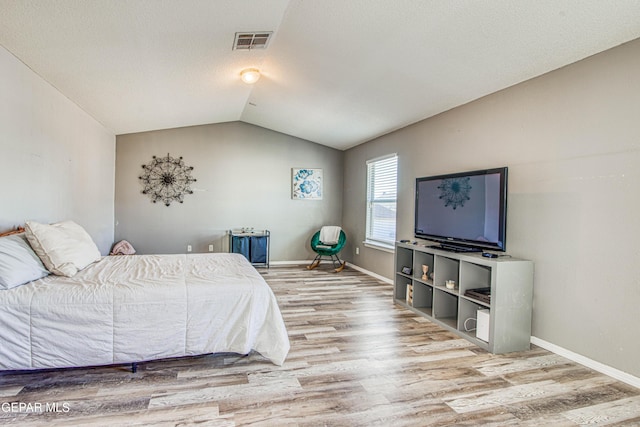 bedroom featuring hardwood / wood-style flooring and lofted ceiling