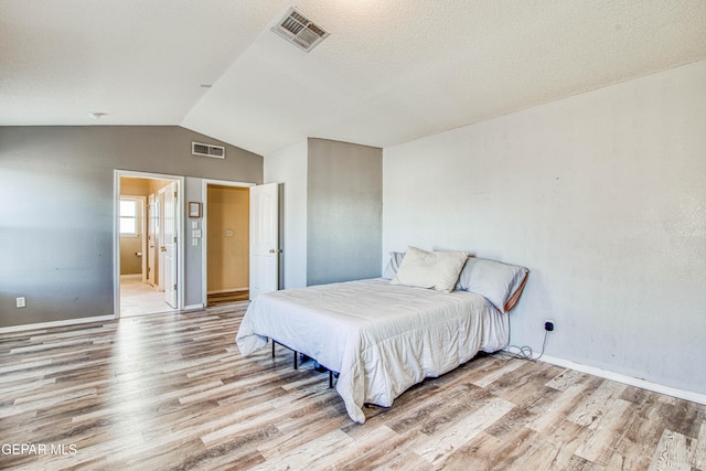 bedroom with vaulted ceiling and light hardwood / wood-style floors