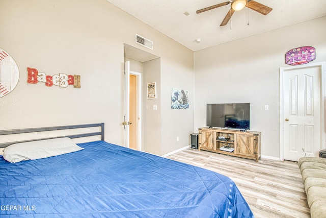 bedroom featuring a textured ceiling, ceiling fan, lofted ceiling, and light hardwood / wood-style floors