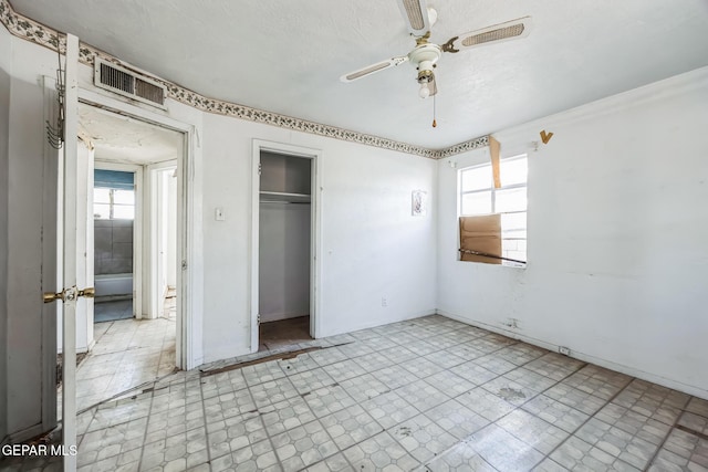 unfurnished bedroom featuring ceiling fan and a closet