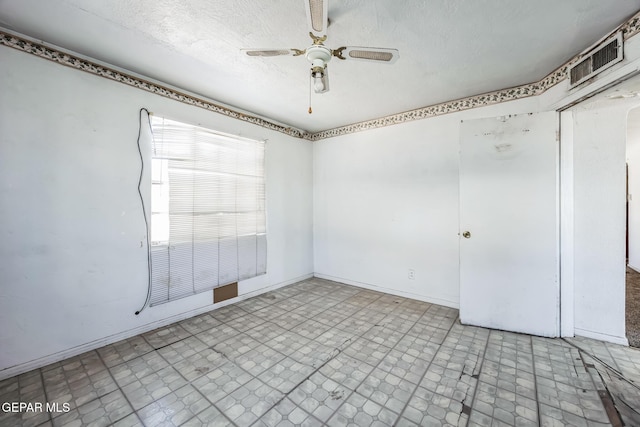 spare room featuring ceiling fan and a textured ceiling