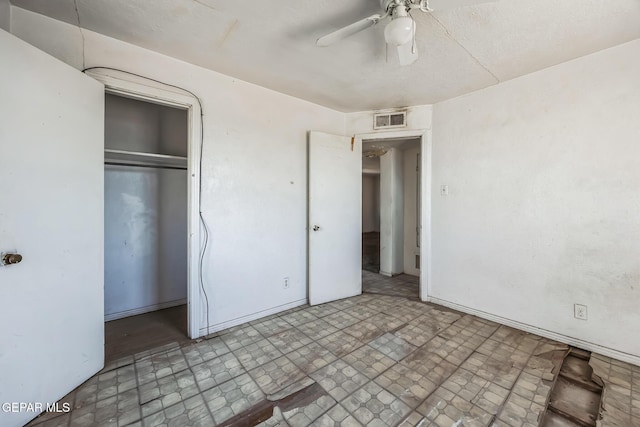 unfurnished bedroom with ceiling fan and a closet