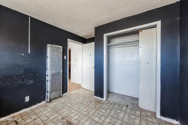 unfurnished bedroom featuring a closet and a textured ceiling