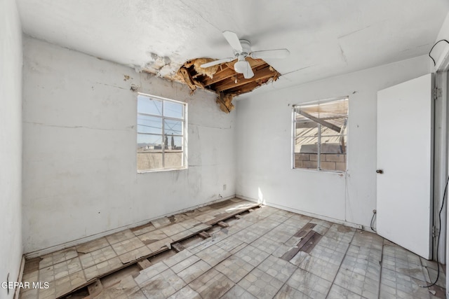 spare room with ceiling fan and a healthy amount of sunlight