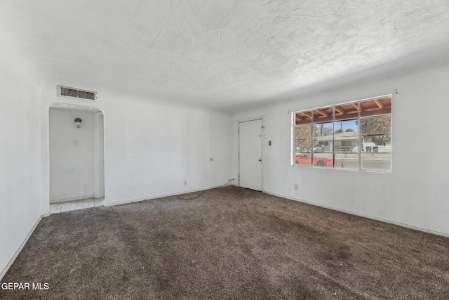 carpeted spare room featuring a textured ceiling