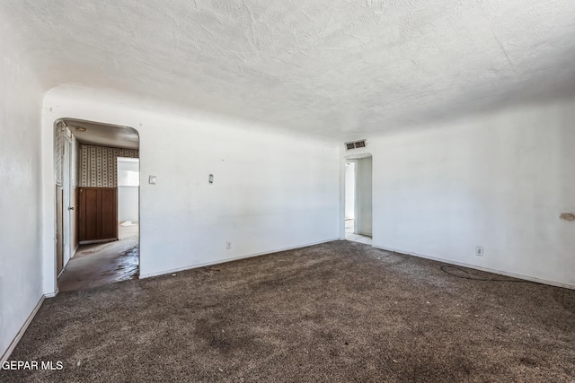 spare room featuring a textured ceiling and carpet floors