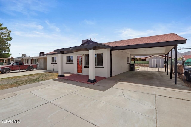 view of front facade with a carport and a storage unit