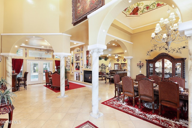 dining area with ornamental molding, french doors, ornate columns, and a high ceiling