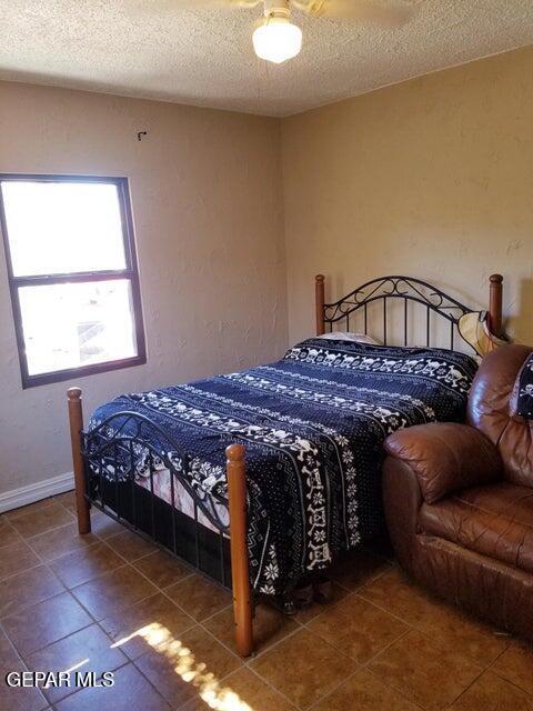 tiled bedroom with a textured ceiling